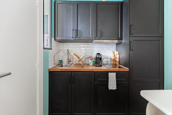 Kitchen equipped with hob, refrigerator, extractor hood, crockery