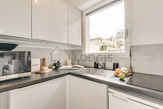 Kitchen equipped with hob, refrigerator, crockery