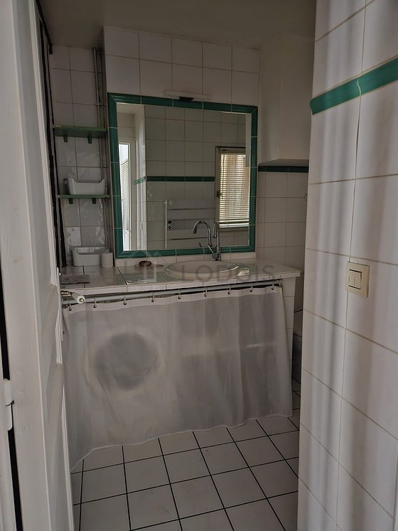 Salle de bain équipée de lave linge, placard