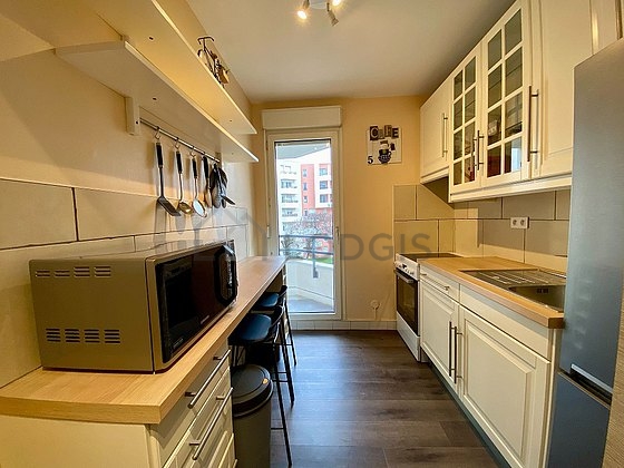 Cuisine équipée de plaques de cuisson, réfrigerateur, hotte, vaisselle