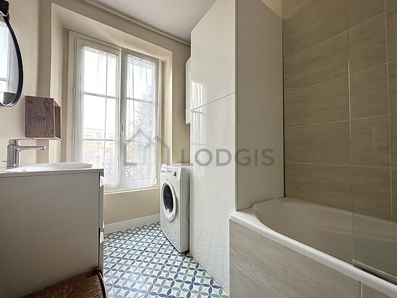 Belle salle de bain claire avec du carrelage au sol