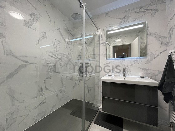 Salle de bain équipée de douche séparée, radiateur sèche-serviettes