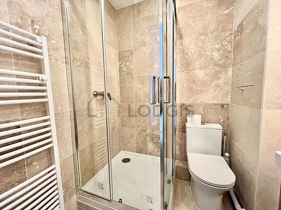 Salle de bain équipée de douche séparée, radiateur sèche-serviettes