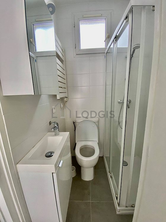 Belle salle de bain claire avec fenêtres double vitrage et du carrelage au sol