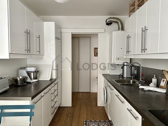 Kitchen equipped with washing machine, refrigerator, extractor hood, crockery