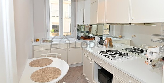 Cuisine équipée de plaques de cuisson, réfrigerateur, hotte, vaisselle
