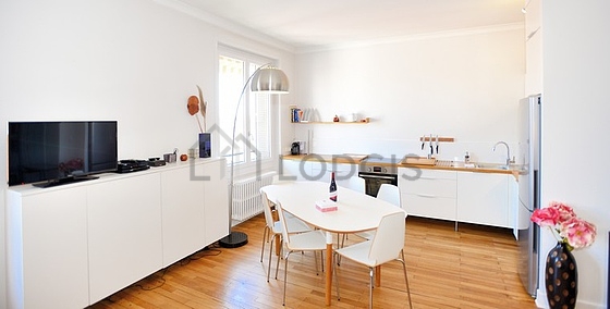 Kitchenopens on the living room with wooden floor