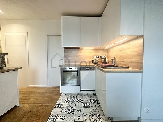 Cuisine équipée de lave vaisselle, plaques de cuisson, réfrigerateur, hotte