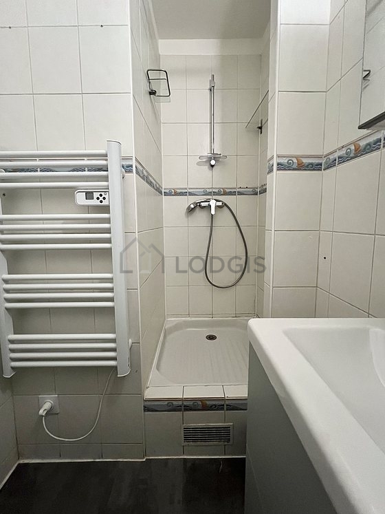 Salle de bain équipée de baignoire, douche séparée, radiateur sèche-serviettes