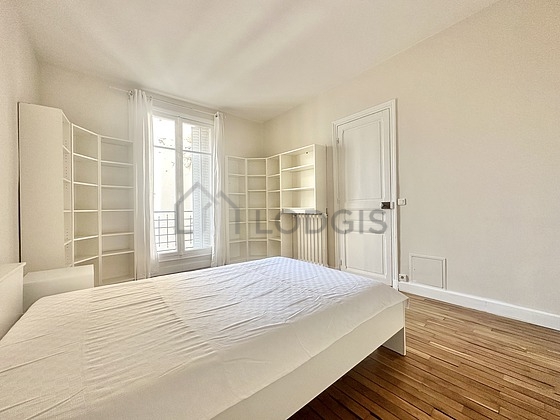 Bright bedroom equipped with cupboard, bedside table