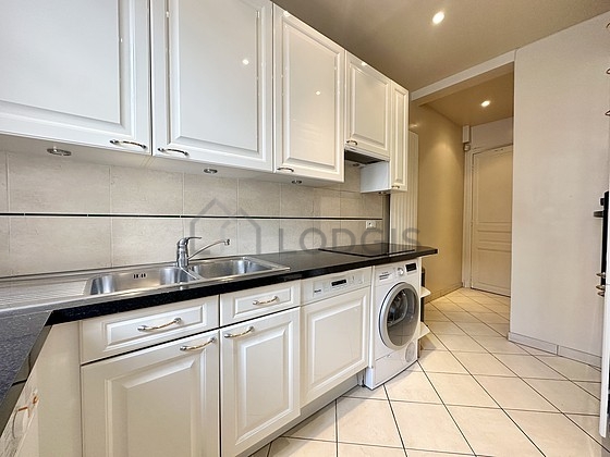 Cuisine équipée de lave linge, sèche linge, réfrigerateur, hotte