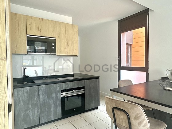 Kitchen equipped with washing machine, kettle, crockery, stool