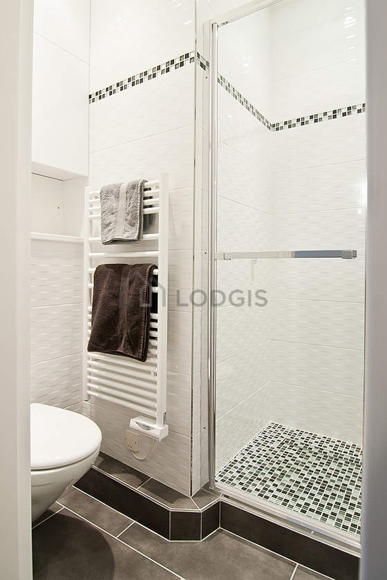 Salle de bain équipée de douche séparée, radiateur sèche-serviettes