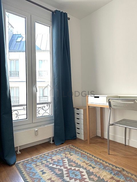 Beautiful office with wooden floor furnished with desk, shelves