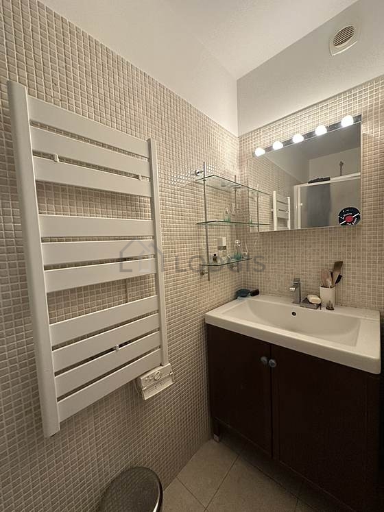 Salle de bain équipée de douche séparée, radiateur sèche-serviettes