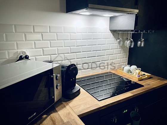 Cuisine équipée de plaques de cuisson, réfrigerateur, vaisselle