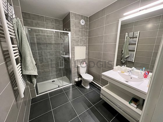 Belle salle de bain claire avec du carrelage au sol