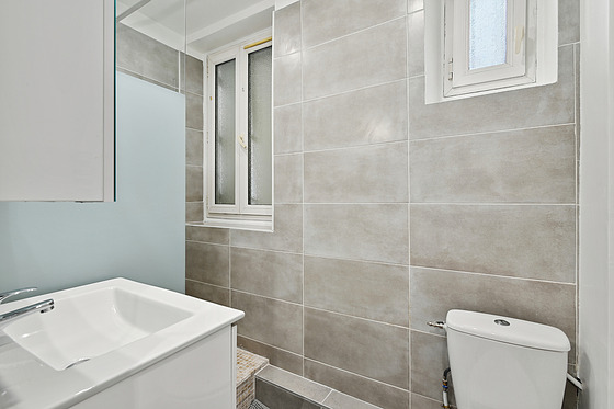 Salle de bain équipée de douche séparée, radiateur sèche-serviettes