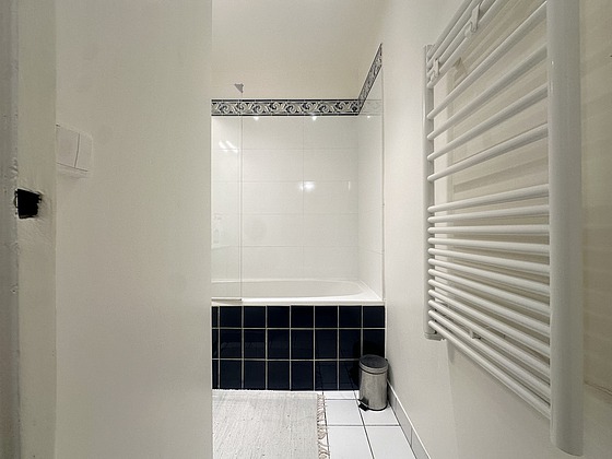 Salle de bain équipée de baignoire, radiateur sèche-serviettes