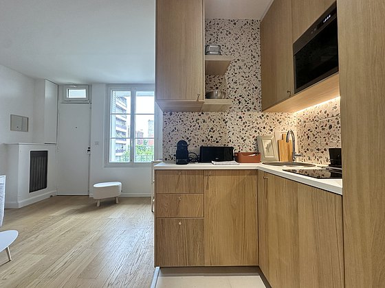 Kitchen equipped with hob, refrigerator, freezer, crockery