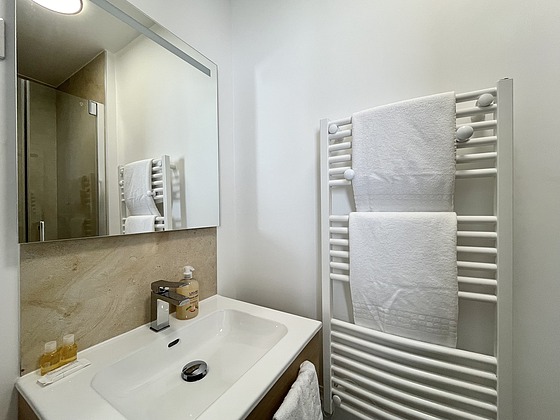 Salle de bain équipée de douche séparée, sèche cheveux