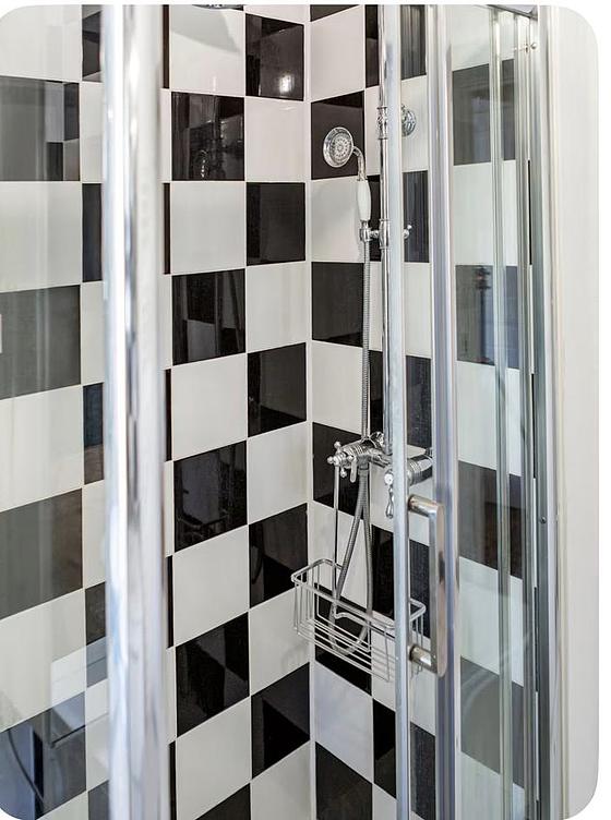 Bathroom equipped with washing machine, separate shower, towel drying radiator