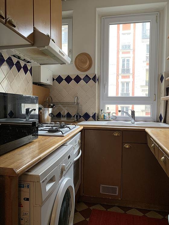 Kitchen equipped with hob, refrigerator, extractor hood, crockery