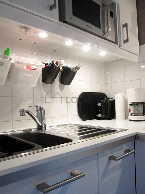 Kitchen equipped with hob, refrigerator, freezer, crockery