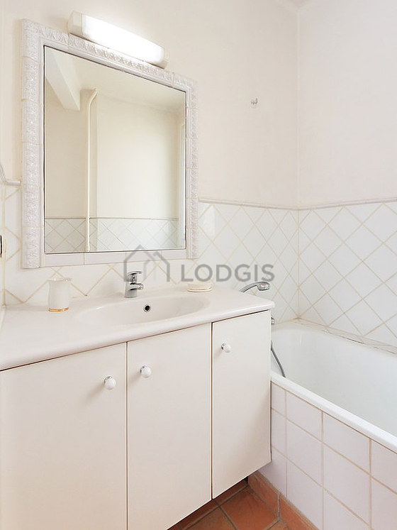 Agréable salle de bain très claire avec fenêtres et du carrelage au sol