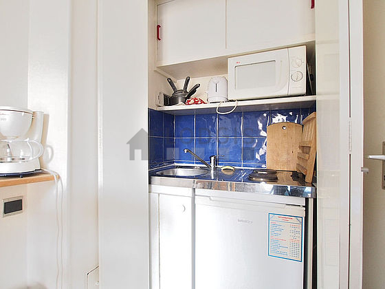 Kitchen equipped with hob, refrigerator, freezer, crockery