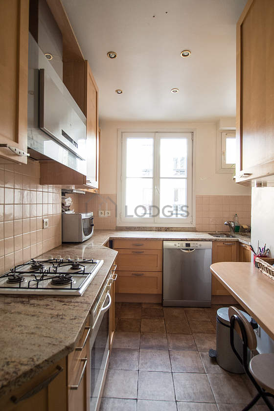 Cuisine équipée de lave vaisselle, plaques de cuisson, réfrigerateur, hotte