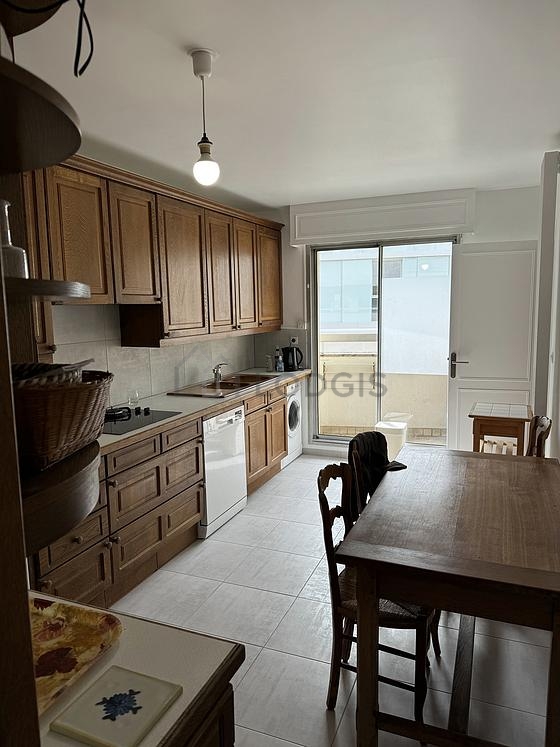 Cusine lumineuse avec fenêtres et balcon donnant sur rue