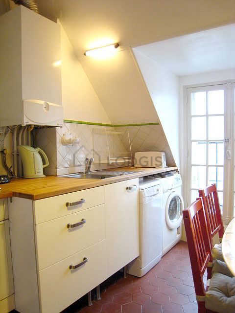 Bright kitchen with windows and balcony facing the road