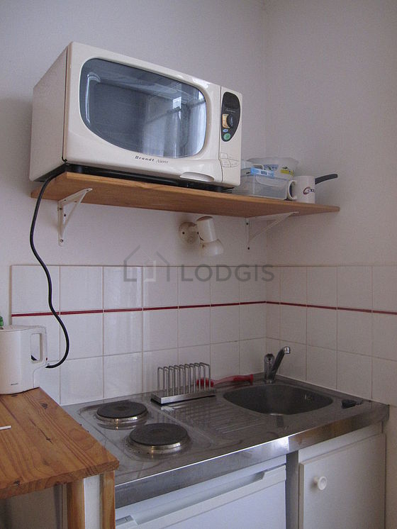Kitchen equipped with hob, refrigerator, freezer, crockery