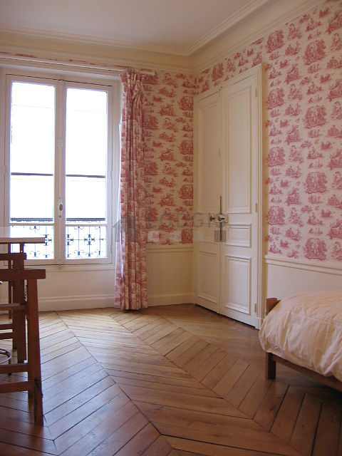 Chambre avec fenêtres donnant sur rue