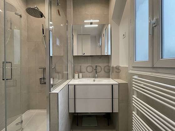 Agréable salle de bain très claire avec fenêtres et du carrelageau sol