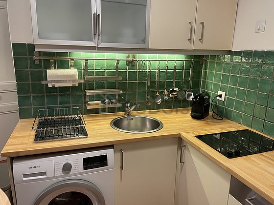 Kitchen equipped with hob, refrigerator, crockery, stool
