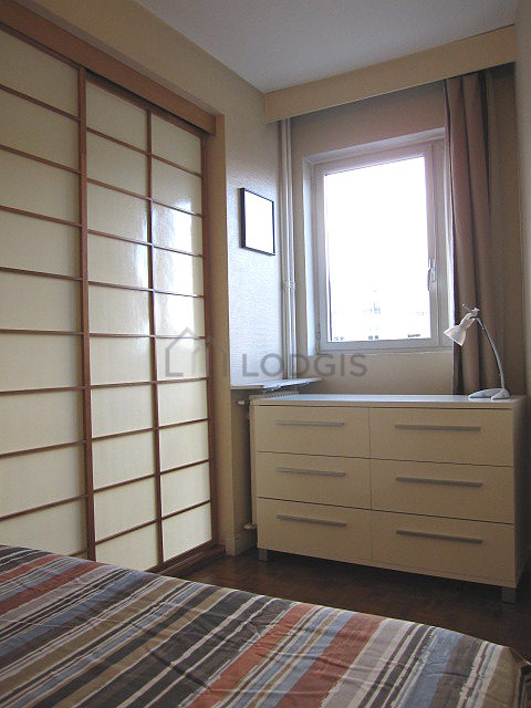 Chambre avec fenêtres double vitrage donnant sur rue