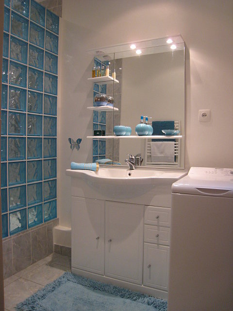 Belle salle de bain claire avec fenêtres double vitrage et du carrelage au sol