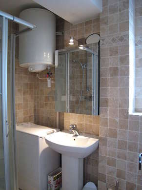 Bathroom equipped with washing machine, separate shower, towel drying radiator