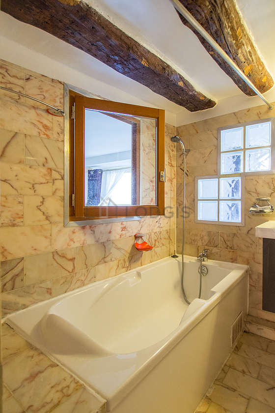 Agréable salle de bain claire avec fenêtres et du marbre au sol