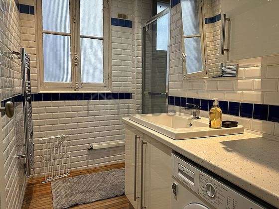 Agréable salle de bain claire avec fenêtres et du parquetau sol
