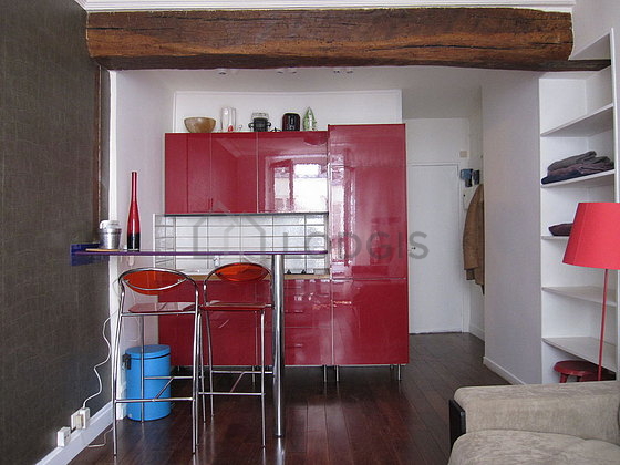 Kitchen equipped with hob, refrigerator, crockery, stool