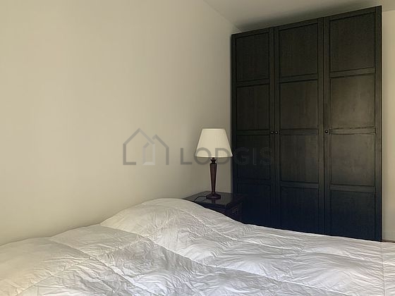 Bright bedroom equipped with tv, bedside table