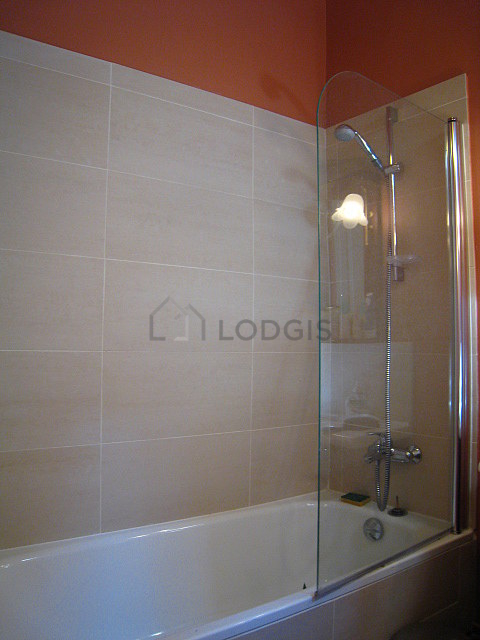 Salle de bain avec fenêtres et des tomettes au sol