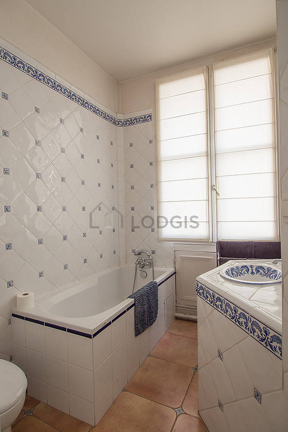 Belle salle de bain claire avec fenêtres et du parquet au sol