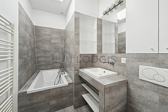 Agréable salle de bain claire avec fenêtres et du carrelage au sol