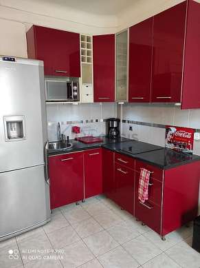 Kitchen equipped with hob, refrigerator, crockery, stool